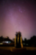 Starry night sky above New Life Foundation retreat showing a sculpture made out to look like multiple peoples' hands