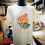 Miniaturbild: weiss meliertes Shirt mit Regenbogenfarbigem Druck; Hang-Loose Hand und Text Aloha is Love