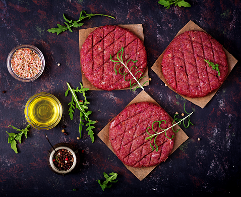 small fresh-raw-homemade-minced-beef-steak-burger-with-spices-black-surface.png
