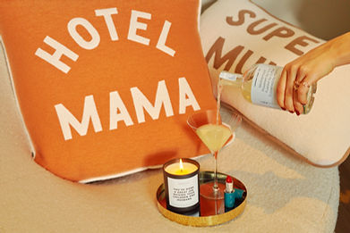 Pouring a cocktail with a candle and cushions in background