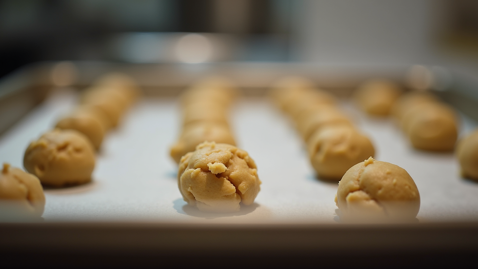 Eye-level view of cookie dough balls arranged on a baking sheet ready for the oven