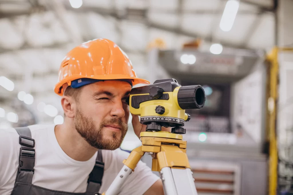 Engenheiro fazendo medições de levantamento topográfico.