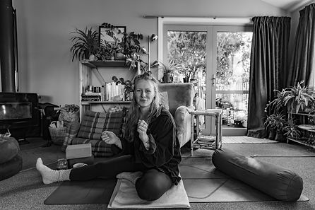 Catalina Dost, yoga therapist, guiding a yoga class in a peaceful indoor setting.
