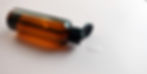 Braune Tonerflasche mit aufgeklapptem Deckel und etwas klarem Urea-Toner daneben auf hellem Hintergrund.