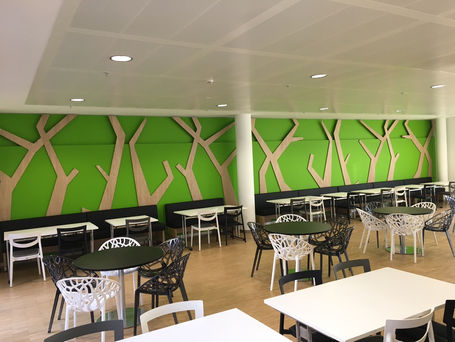 Cafétéria avec décoration murale arborée.