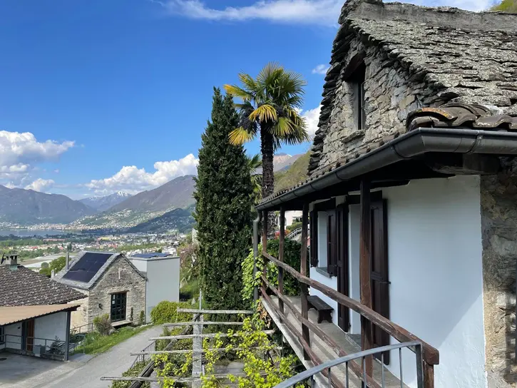 ferienhaus in der schweiz, im tessin, der süd-schweiz, es ist ein altes Steinhaus, ein sogenanntes Rustico, wir wollen dieses haus für interessierte reisende, für touristen, für urlaubssuchende präsentieren. das steinhaus schmiegt sich an einen Hang der Südalpen, ist umgeben von bergen, und man blickt hinunter auf den See Lago maggiore. das grundstück, der garten ist eine kleine in sich geschlossene Welt, voll mediterraner pflanzenpracht, voller palmen, kamelien und azaleen, voller geschützter sitzplätze, sei es unter einer Wein-Pergola oder auf der erhöhten Aussichtsterrasse, es ist ein ort um die Natur, die landschaft, die ruhe, die berge, den see, das mittelmeer-klima in sich aufzunehmen. ein ort an dem das herz sagt "la vita é bella"