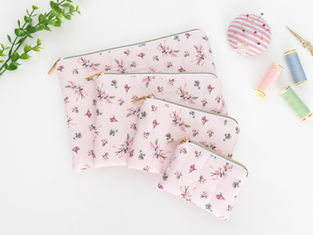 A set of 4 flat, quilted zipper pouches in a pretty pastel pink floral fabric.