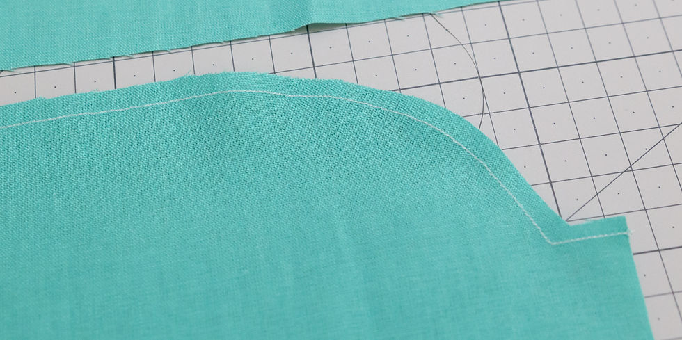 Some green fabric showing stay stitching.