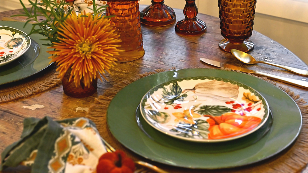 Fall table with stacked plates,, amber glass, and mum flowers