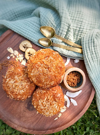 Gluten free banana muffins topped with coconut shavings.