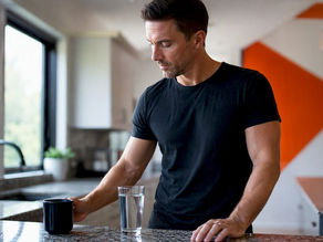 Close-up of morning water and coffee cup on kitchen counter