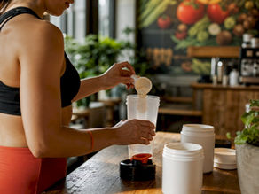 Woman preparing pre-workout drink at home kitchen