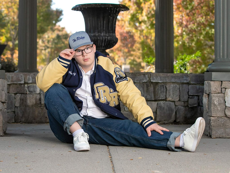 Christopher in Letterman Jacket sitting on ground.jpg