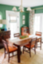 Traditional dining room with green walls, floral drapery, and refurbished antiques.
