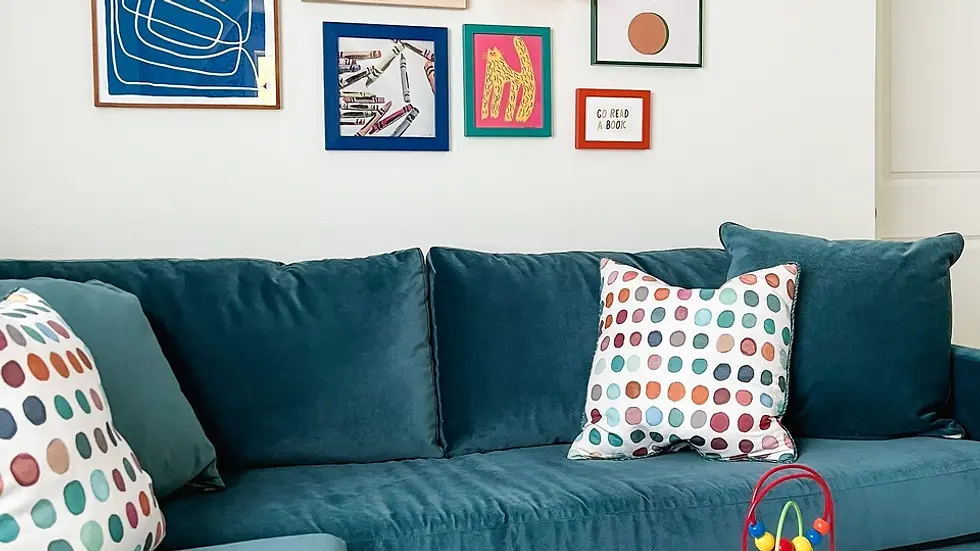A blue velvet pullout sectional with a whimsical art gallery wall in a children's playroom.