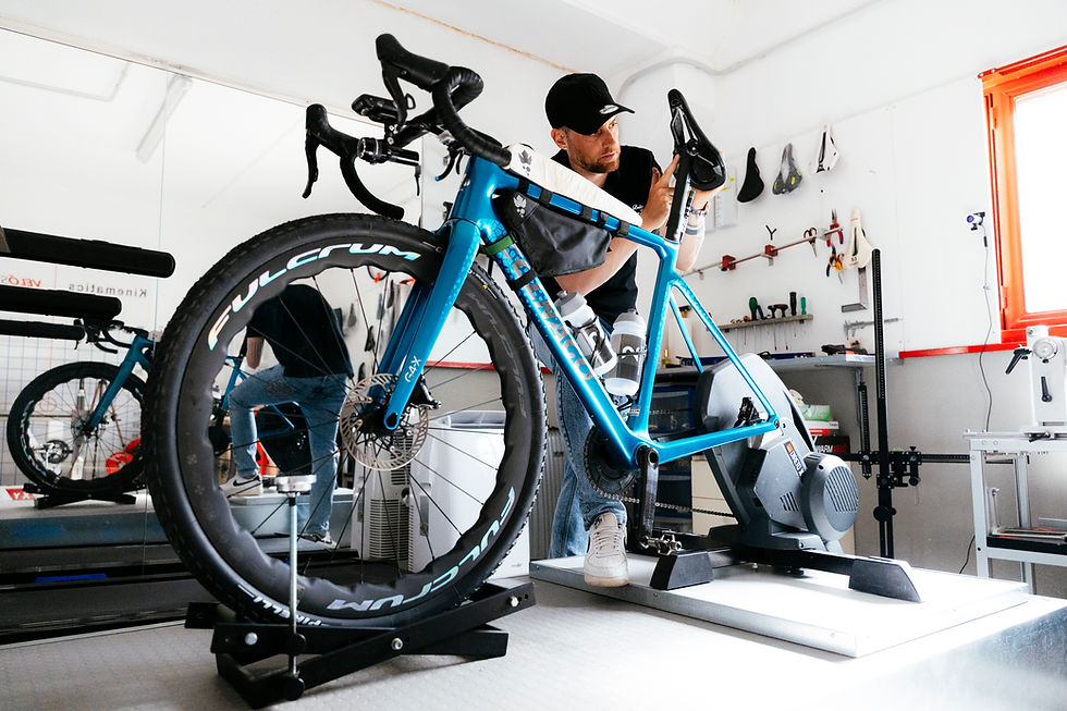 Tecnico esegue un bike fitting su bici da corsa azzurra.