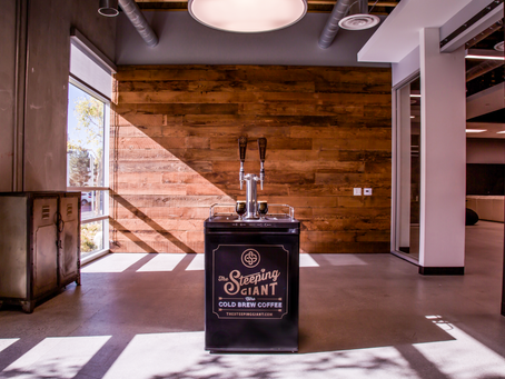 The Steeping Giant nitro cold brew coffee kegerator setup inside a modern office space with wood accent walls and natural lighting in North County San Diego.