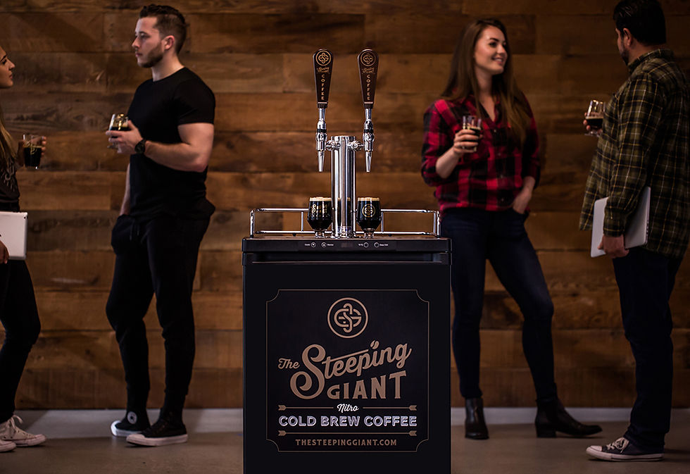 Employees gathering around The Steeping Giant nitro cold brew coffee tap system inside a modern office space in North County San Diego.