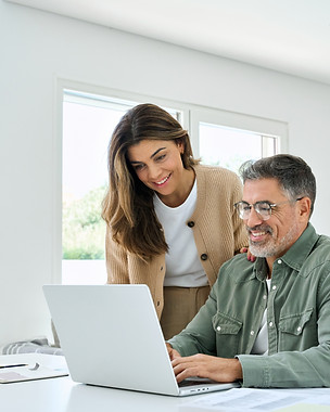 Couple searching for their next home together on a laptop