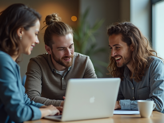 Três colegas de trabalho colaboram animadamente em um projeto no escritório, compartilhando ideias diante de um laptop.