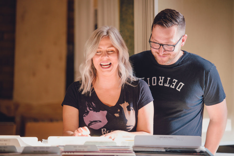 a man and a woman are laughing and the man is wearing a detroit shirt