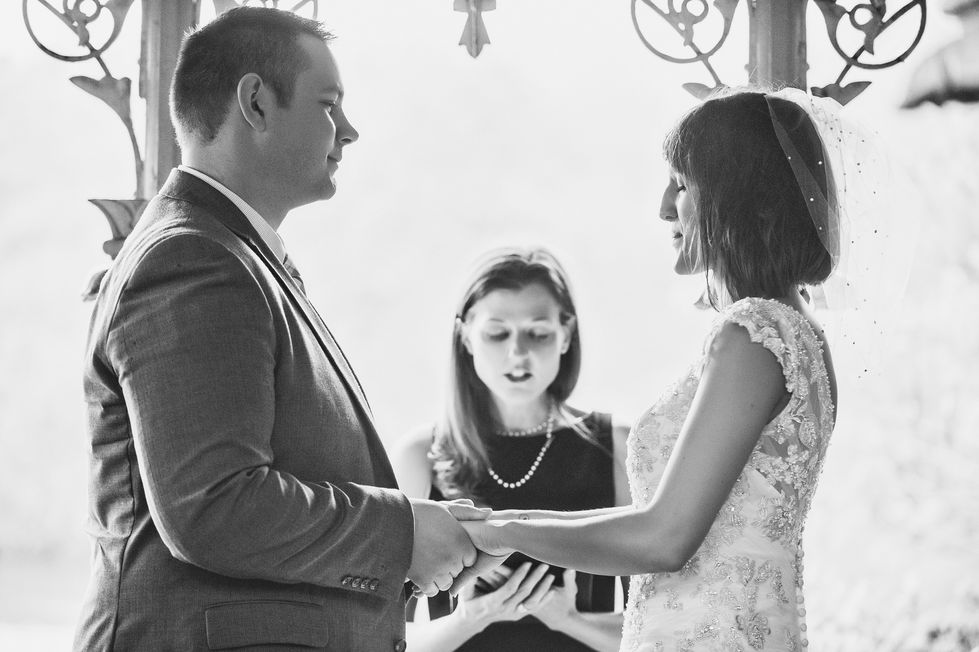 a black and white photo of a bride and groom holding hands