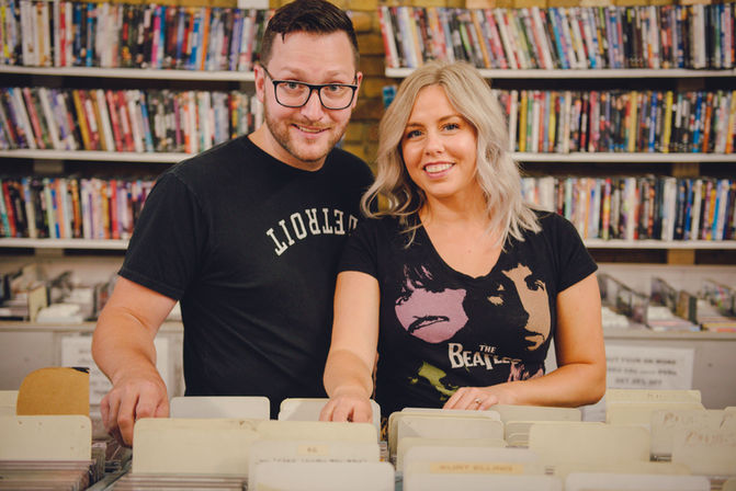 a man and a woman standing next to each other wearing beatles shirts