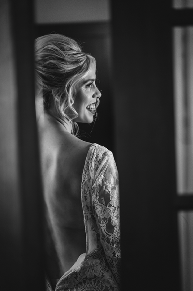 a woman in a lace dress is smiling in a black and white photo