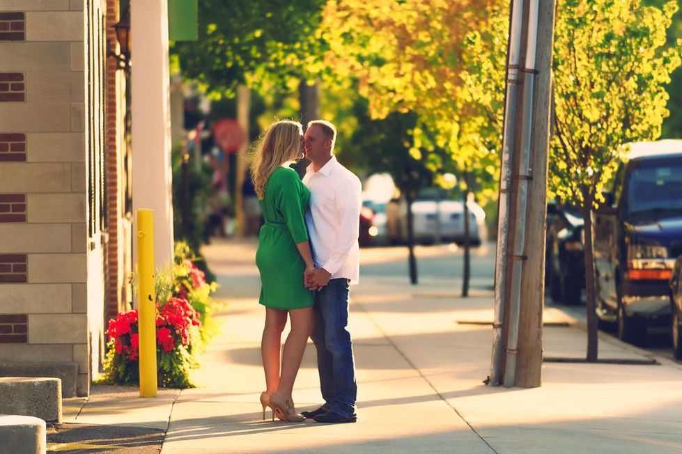 a woman in a green dress kisses a man on the cheek