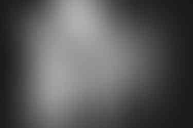 a black and white photo of a woman looking at herself in a mirror