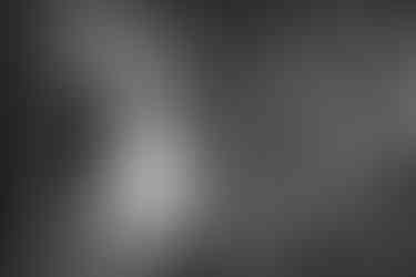 a black and white photo of a bride and groom under an umbrella