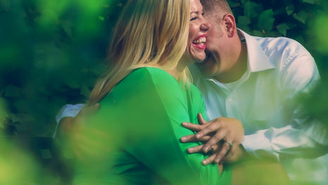 a man kisses a woman on the cheek while she smiles