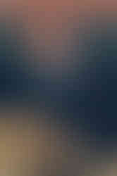 a woman in a blue and green dress is hugging a man in a white shirt