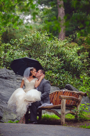 a bride and groom are kissing under an umbrella