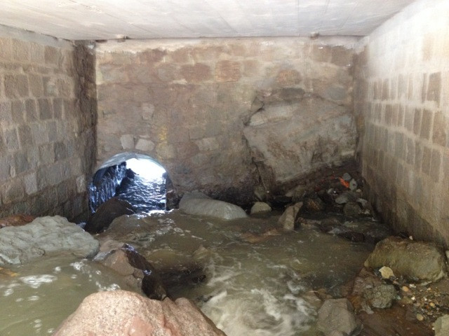 Puente con muro que interrumpe flujo de agua
