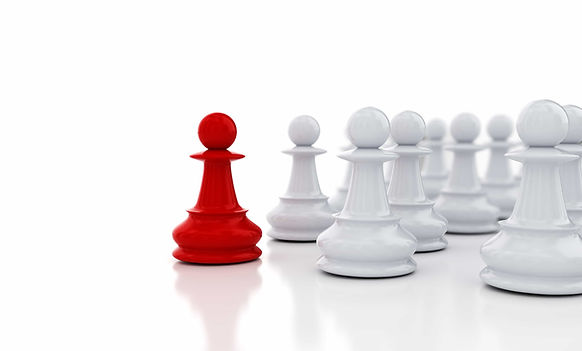Red chess piece surrounded by several white ones to its side, all against white background and white reflective surface