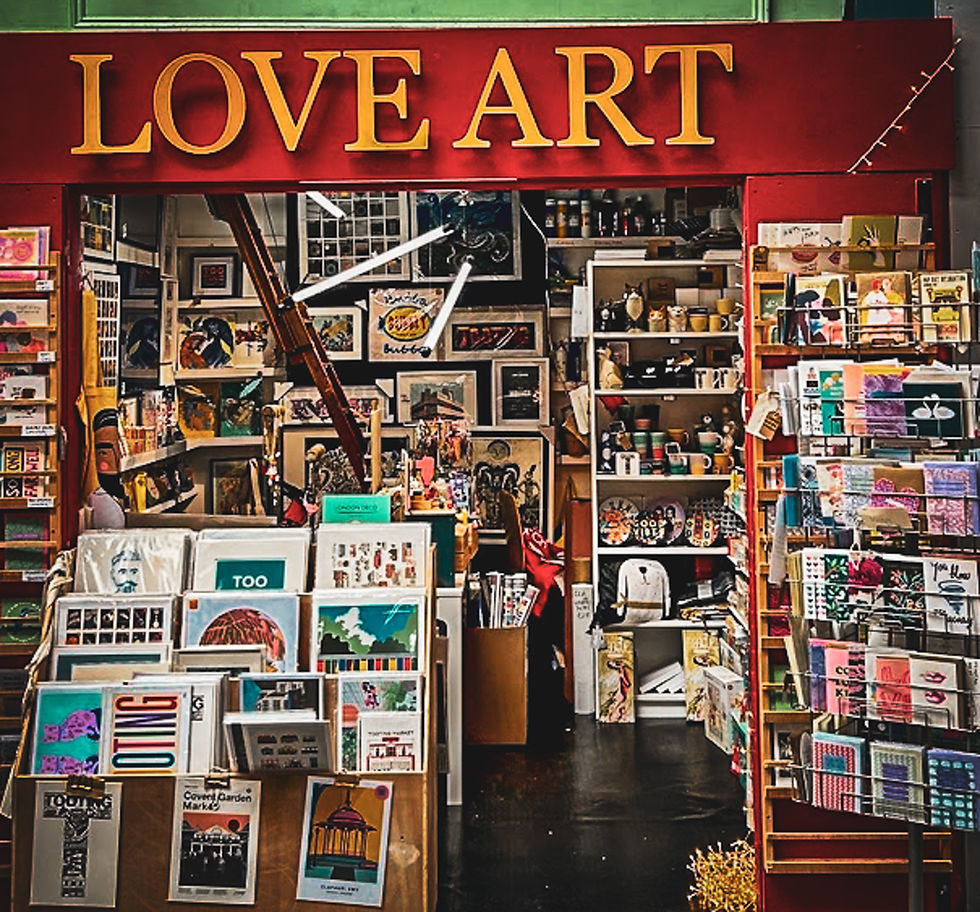 Boutique d’art colorée avec l’enseigne LOVE ART, murs couverts de tableaux et cartes, ambiance créative et foisonnante.