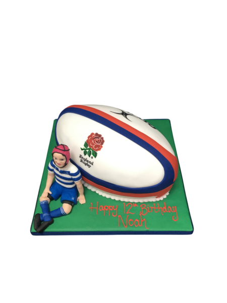 A rugby-themed cake featuring a rugby ball and player figurine on top, perfect for sports-themed celebrations.