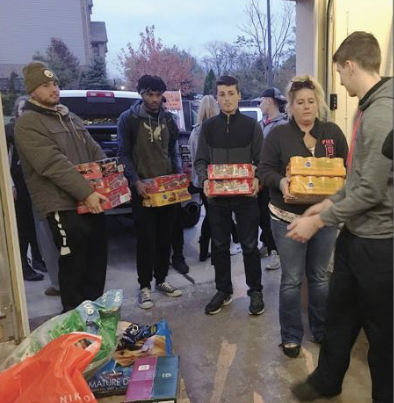 Volunteer helping to carry the cans to the shelter