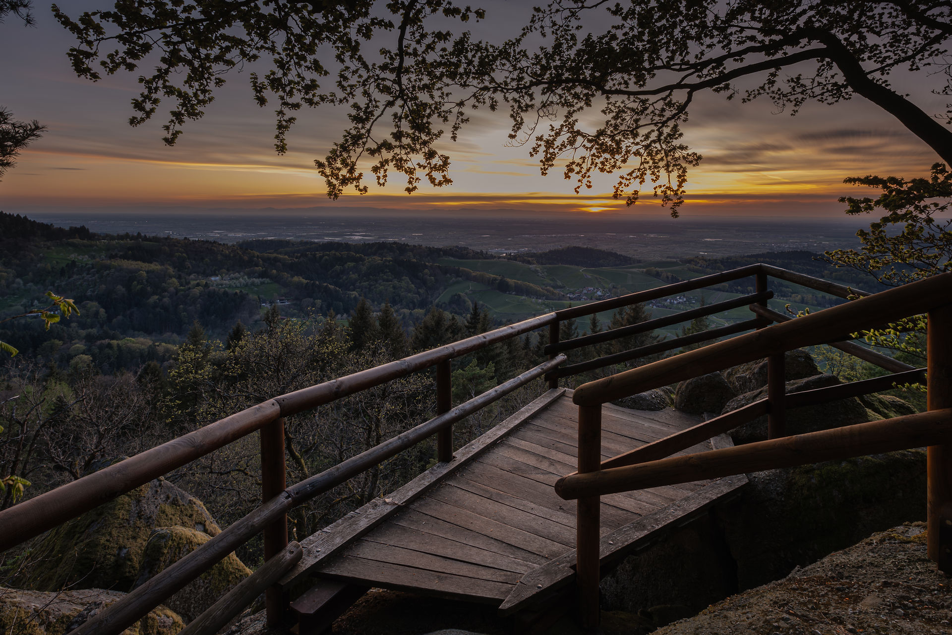 Orangener Himmel hinter einer Holz-Plattform