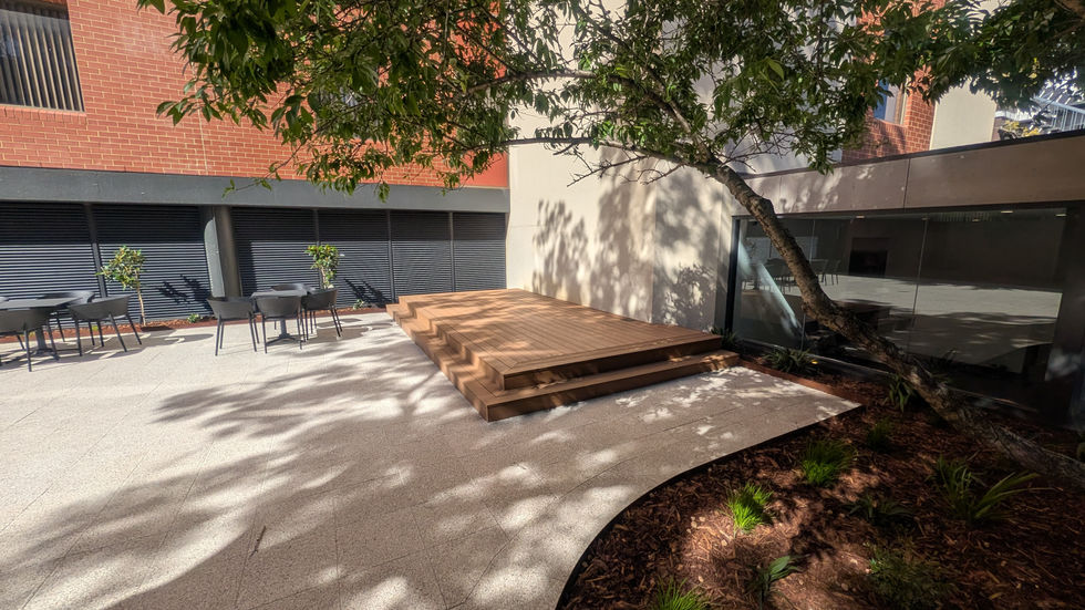 perspective showcasing the comprehensive transformation of the underutilized outdoor space into a vibrant, multi-functional courtyard connecting the hospital lobby and street-facing café.