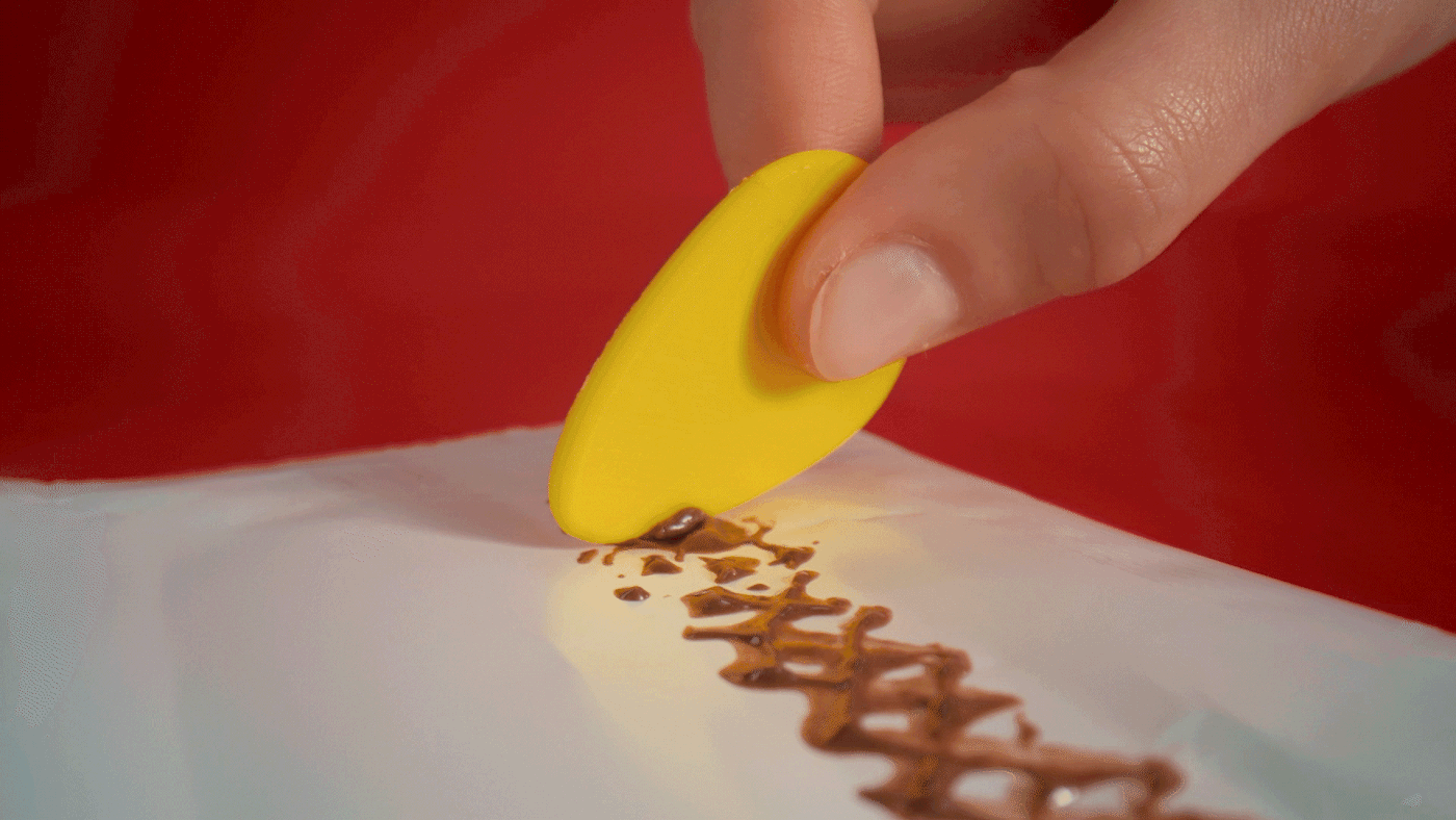 The spoon scoops melted chocolate from the wrapper.