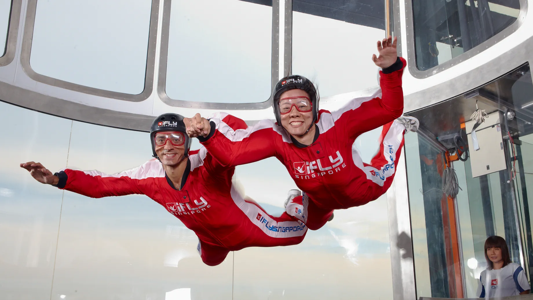 Woman having a simulated skydiving experience at iFly Singapore with instructor