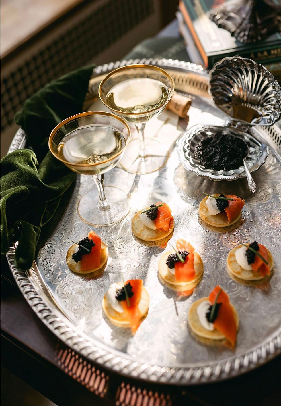 A silver tray of caviar and champagne in coupe glasses