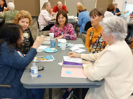 Members of a book club discuss the book around a table