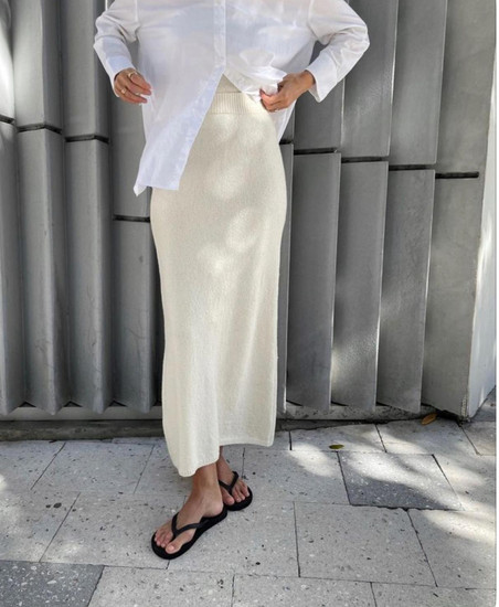 Girls wearing a silk skirt white shirt and flip flops 