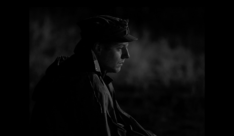 Memoirs of an Unknown Soldier Film Still: Świerk sits dejected in the dark while on guard duty at night.
