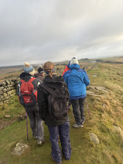 Group walks along Hadrian's Wall on a cloudy day, Women Walk the Wall. curiuscompass