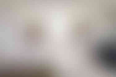 Elegant bedroom with large windows, bed, couch, and fireplace. curiuscompass