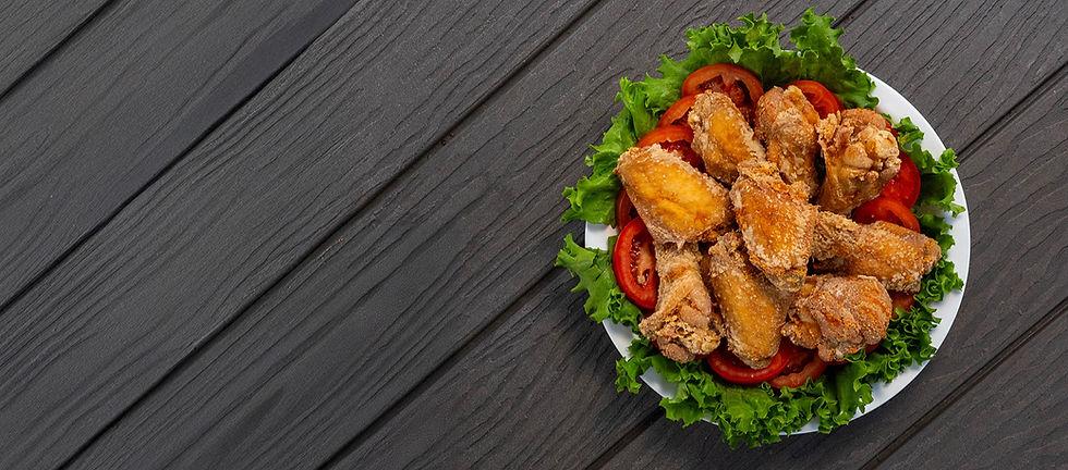 Photo of chicken wings on a plate on a grey wooden table